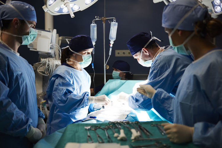 Doctors operating patient in emergency room