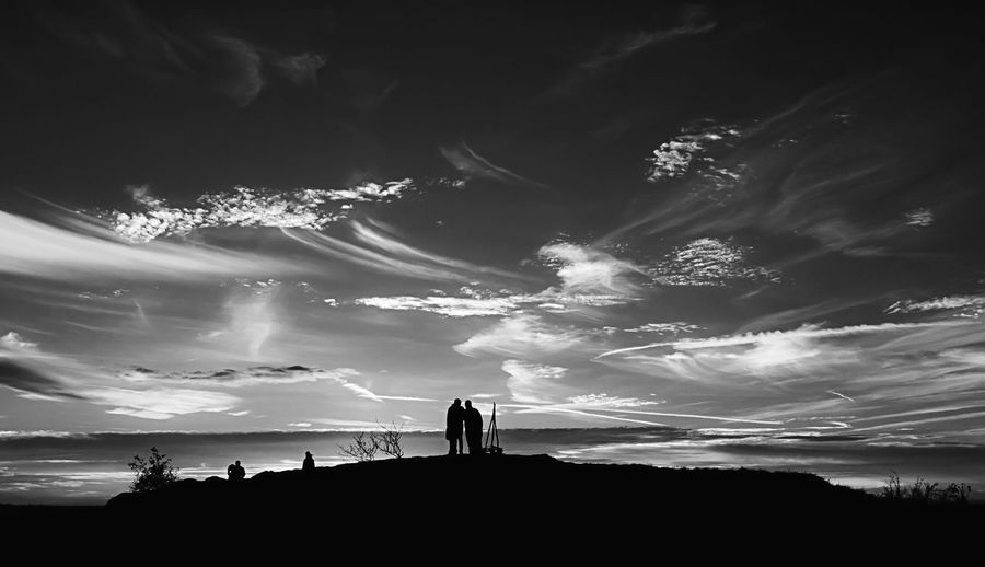 Silhouette people standing against sky