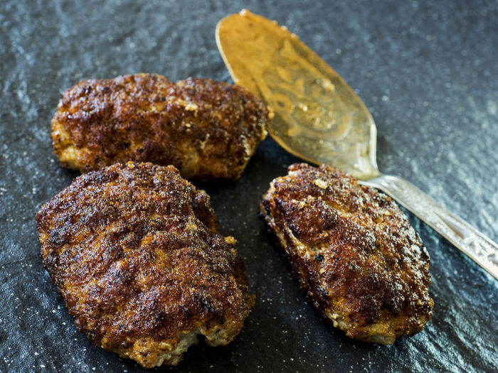 Close-up of cutlets served by spoon in stone plate
