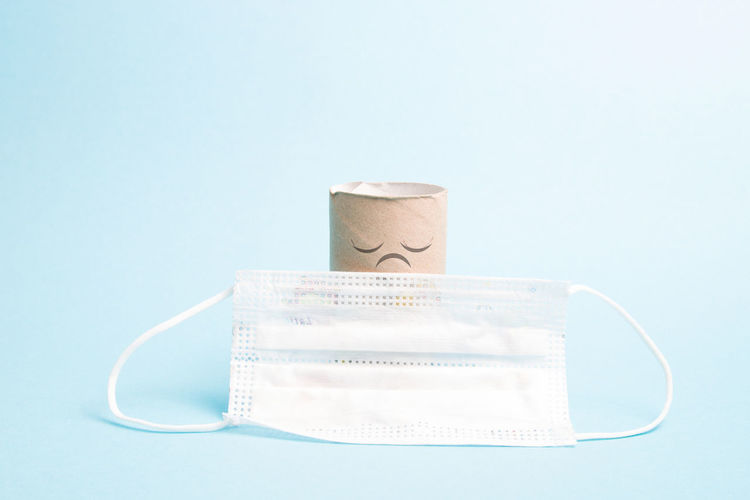 Close-up of surgical mask over colored background