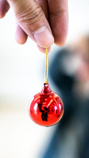 Close-up of hand holding red bauble