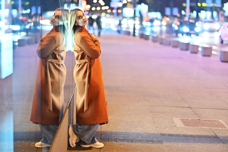 Woman standing on street at night