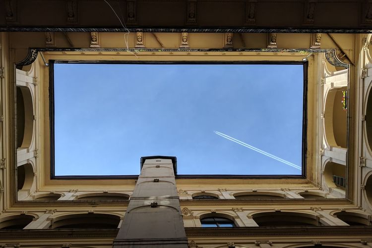 Directly below shot of sky seen through building