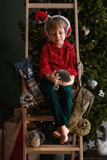 Portrait of boy playing with christmas tree