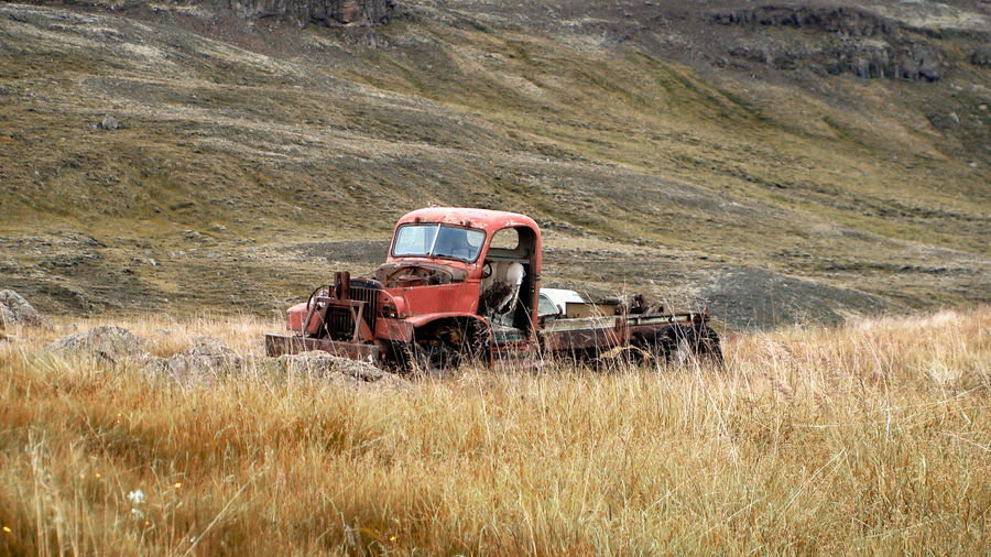 Abandoned truck standing on field