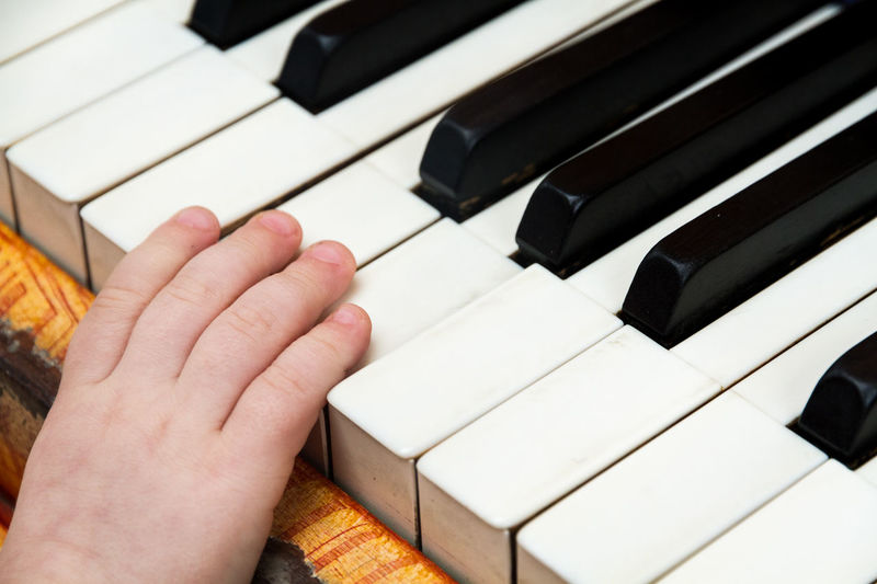 Cropped hand of baby boy playing piano
