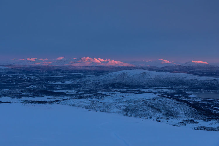 Scenic view of snowcapped mountains against clear sky during sunset