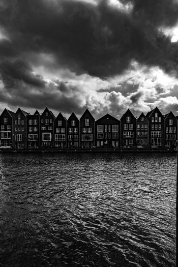 Houses by sea against sky