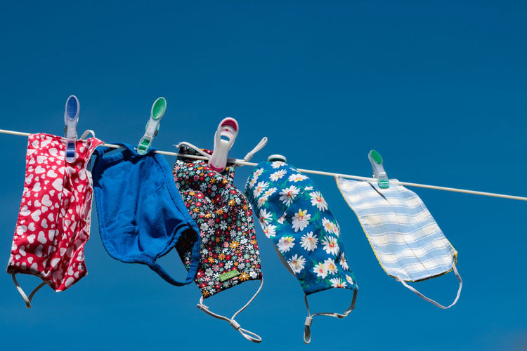 Low angle view of clothes hanging on clothesline against blue sky