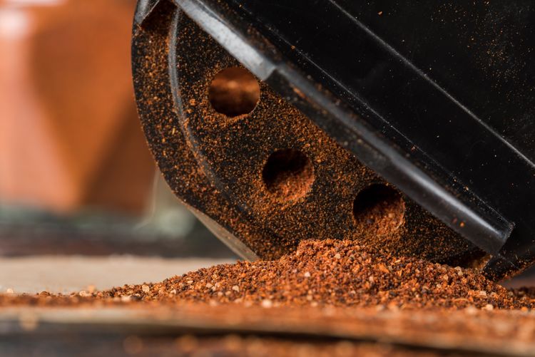 Close-up of red chili powder by grinding machine