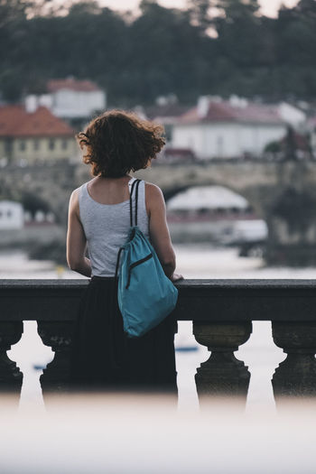 Young european girl look at charles bridge from vltava river, prague.