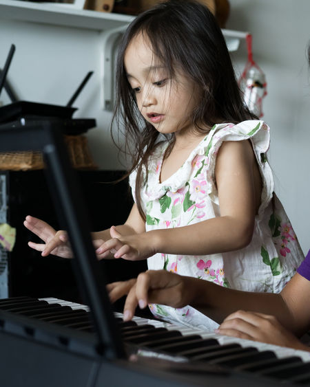 Happy kids playing piano at home
