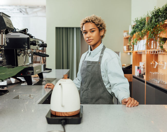 Portrait of young woman standing in factory
