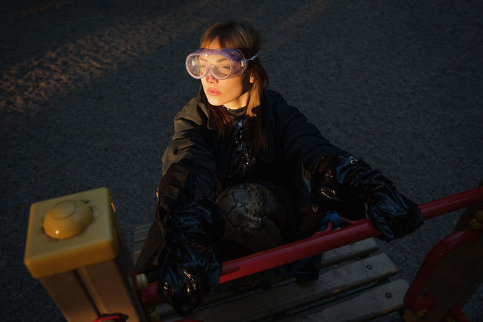 High angle view of woman wearing eyewear while sitting in playground
