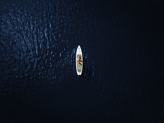 Aerial view of woman paddleboarding on sea