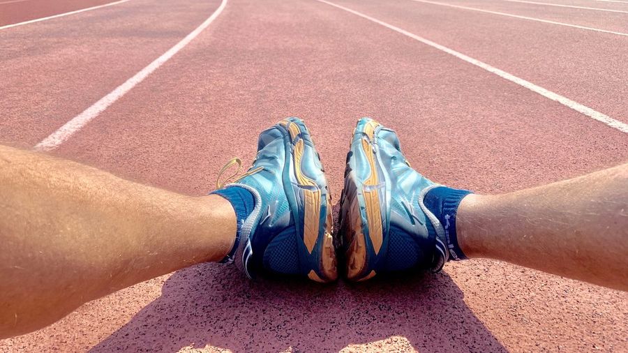 Low section of man relaxing on running track