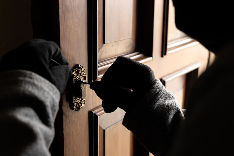 Thief picking a lock on a door. concept of home burglary and home thieves