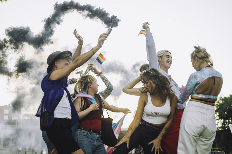 Happy multiracial friends dancing while enjoying at gay pride parade