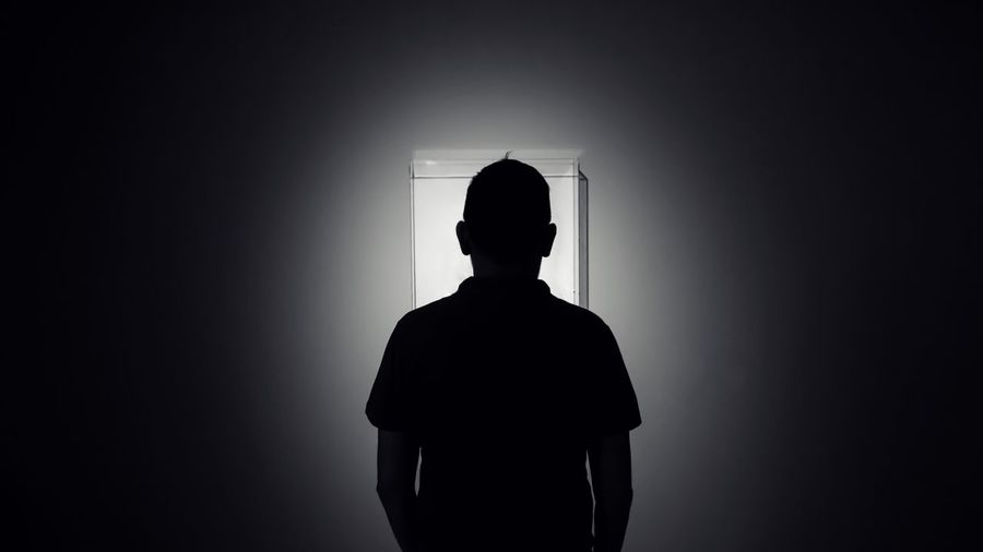 Silhouette man standing in darkroom