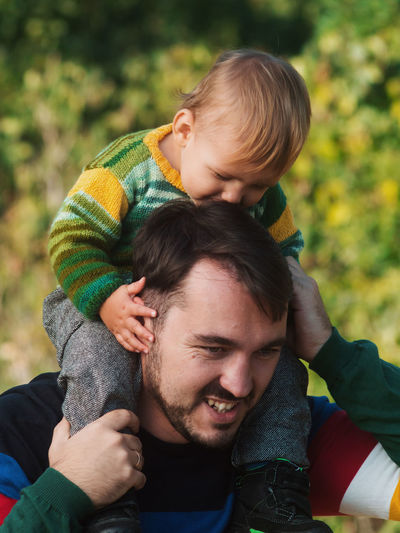 Close-up of father carrying son on shoulder