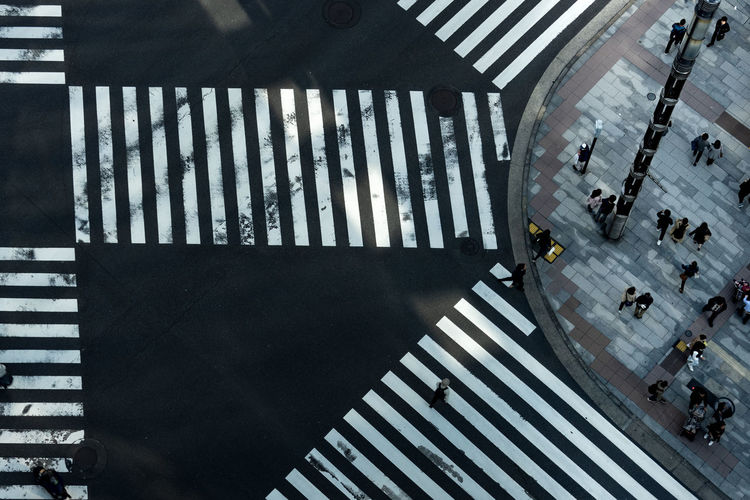 High angle view of people walking on tiled floor in city