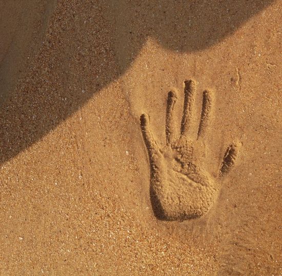 High angle view of handprint on sand at beach