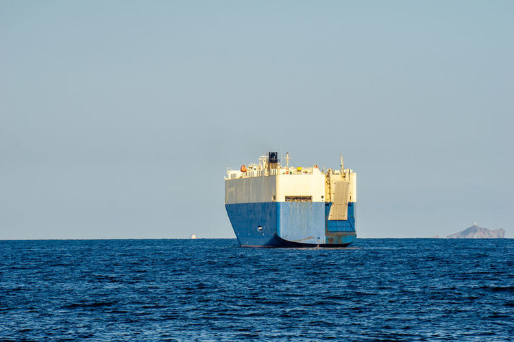 Container ship in sea against clear sky