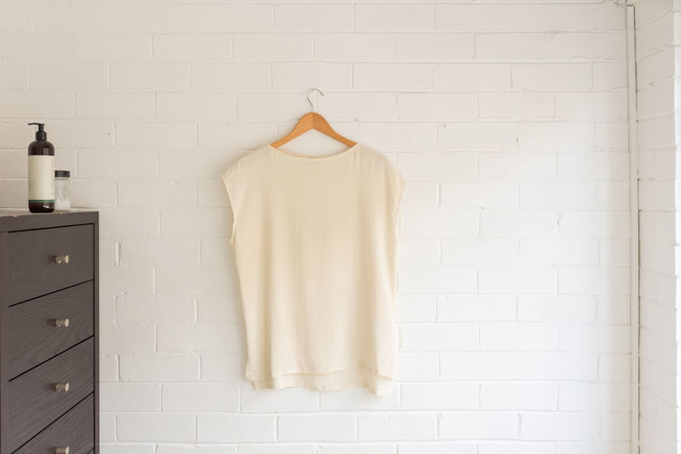 Clothes hanging on white wall at home