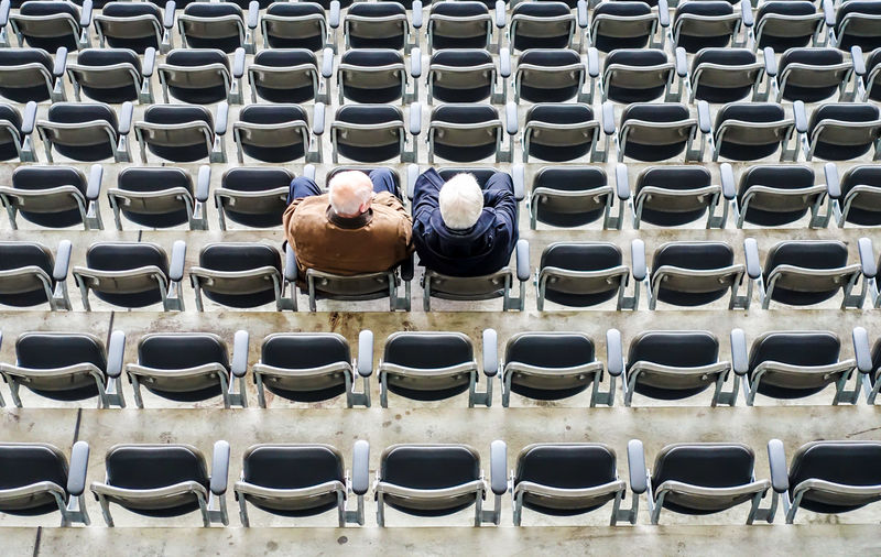 High angle view of friends sitting on chairs at stadium