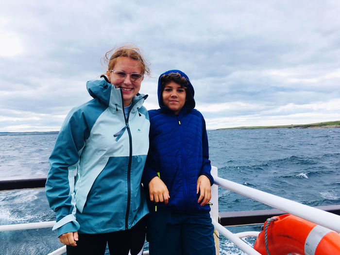 Portrait of friends standing against sea