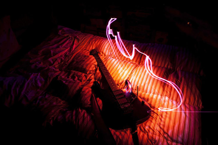 High angle view of guitar on bed at home