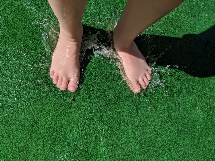 Low section of woman standing on turf