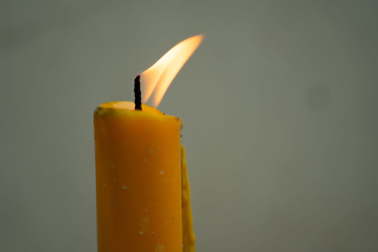 Close-up of yellow candle against black background