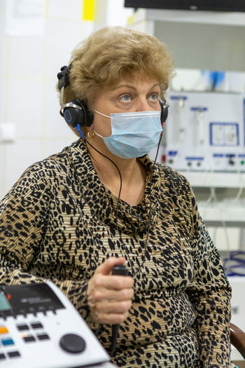 Audiologist checks the hearing of an older woman