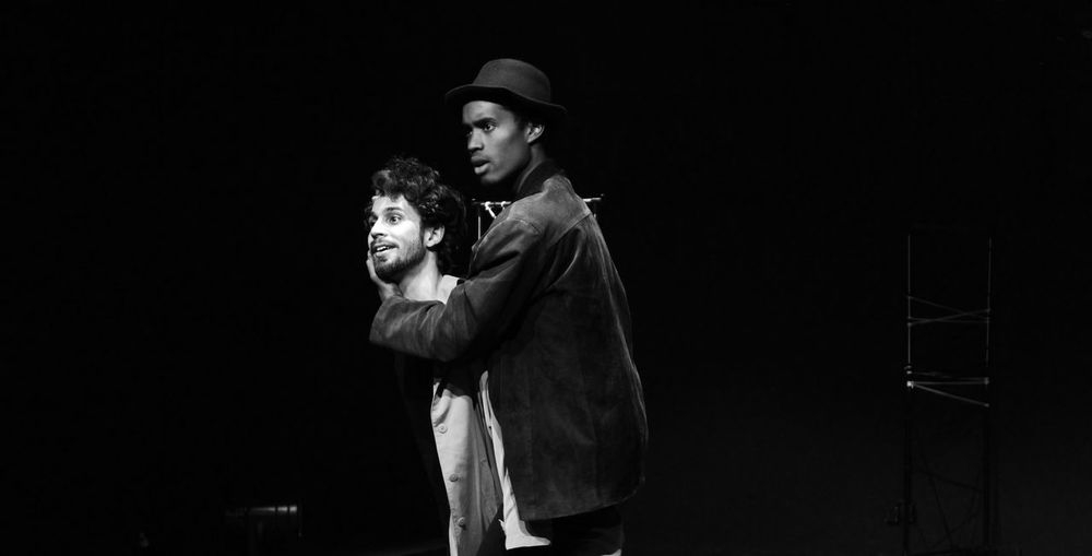 Men performing against black background