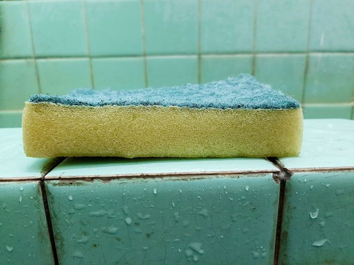 Close-up of cleaning sponge on wet floor