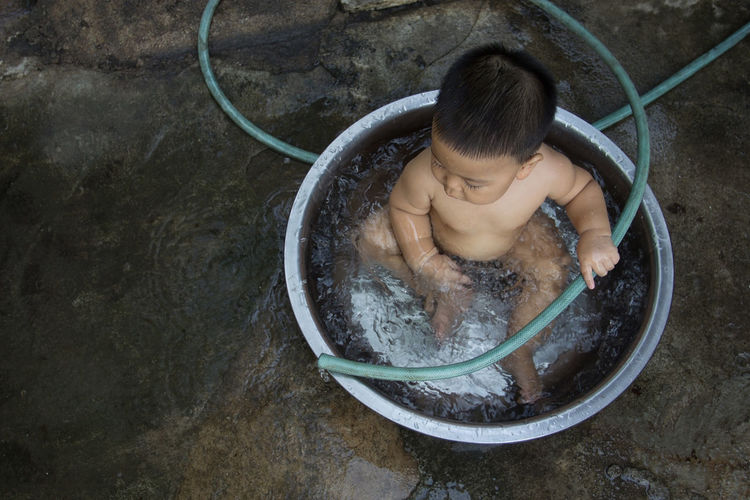 High angle view of shirtless boy in water