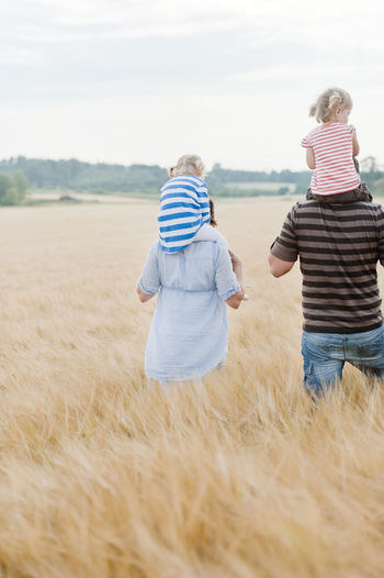 Family with two children walking in field