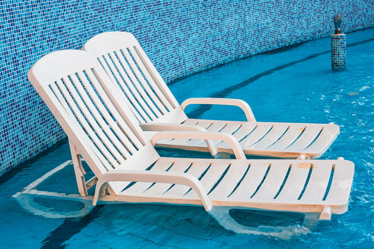 High angle view of empty chairs at swimming pool