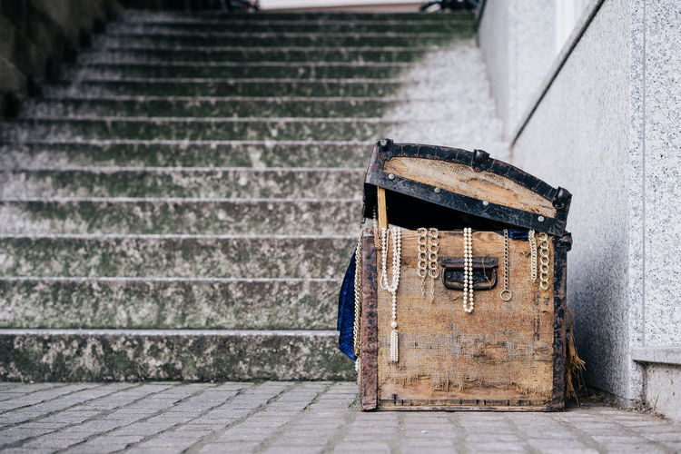Old treasure box by staircase against wall