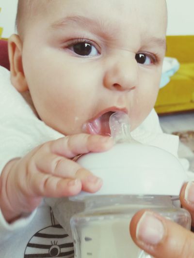 Portrait of cute baby boy drinking milk