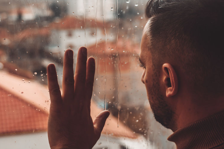 Portrait of man looking through glass window