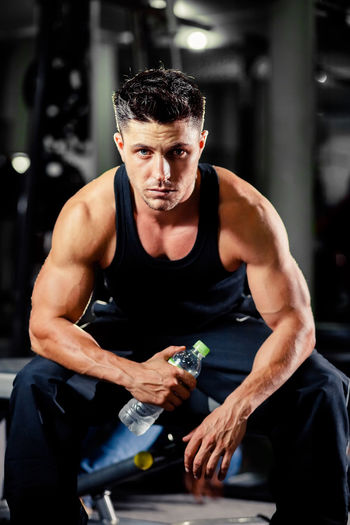 Portrait of muscular man sitting at gym