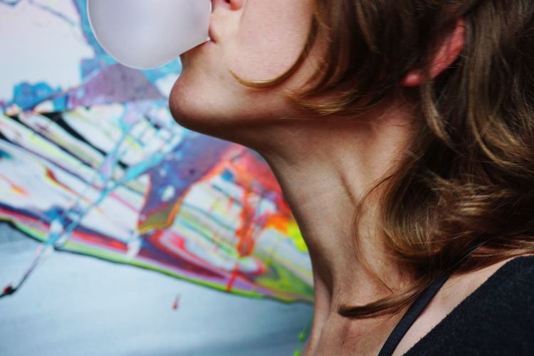 Close-up of woman blowing bubble gum