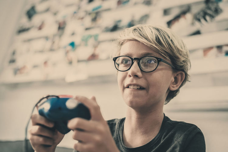 Close-up of boy playing with video games 