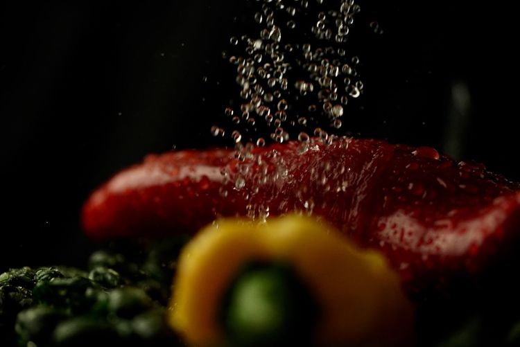Close-up of berries on water against black background