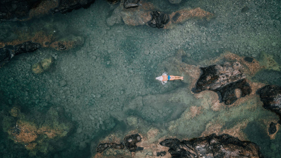 Drone view of man swimming in sea