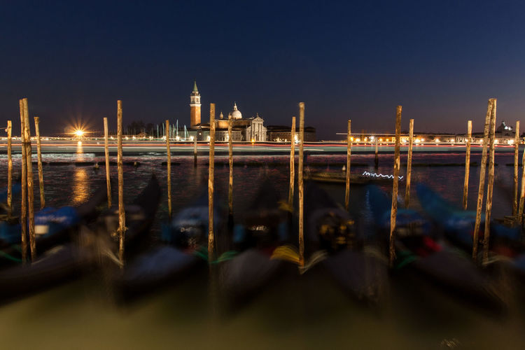 Blurred motion of gondolas moored on grand canal against st marks square at night