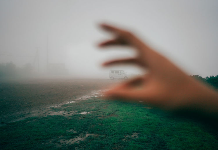 Person on grassy field during foggy weather