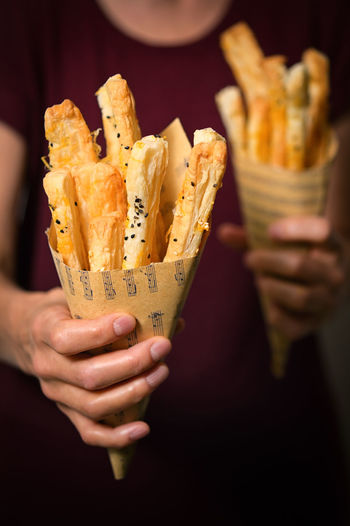 Salted cheese straws and sesame seeds in a paper cone